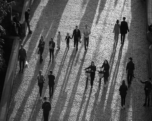 happy people walking in a city park with green trees